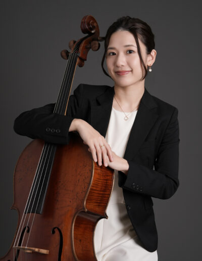 グレー背景で撮影したチェロを持った女性音楽家のプロフィール写真