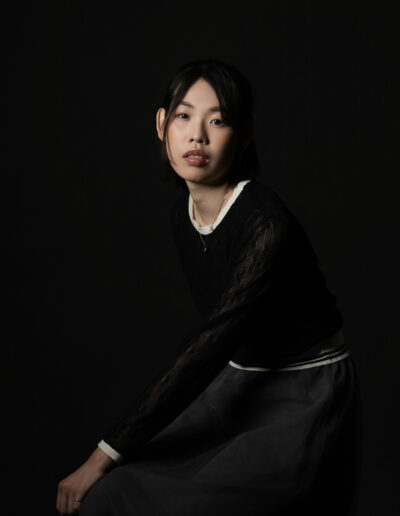 黒背景で撮影した女性モデルのプロフィール写真